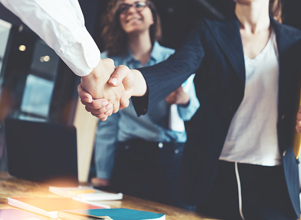 Photo of business people shaking hands in the office.